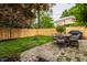 Landscaped backyard featuring a patio with dining set, fire pit, wooden fence and lush green grass at 5430 N Washington Blvd, Indianapolis, IN 46220