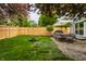 Beautiful backyard with patio, dining table, fire pit, wooden fence and green lawn at 5430 N Washington Blvd, Indianapolis, IN 46220