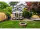 Spacious backyard with dining set, fire pit, wooden fence, lush lawn, and gray home exterior at 5430 N Washington Blvd, Indianapolis, IN 46220