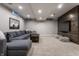 Finished basement with wall paneling, modern sofa, decorative pillows, and neutral carpeting at 5430 N Washington Blvd, Indianapolis, IN 46220