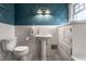 Traditional bathroom with a pedestal sink, tiled walls, decorative wallpaper, and patterned flooring at 5430 N Washington Blvd, Indianapolis, IN 46220