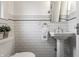Elegant powder room with subway tile walls, pedestal sink, and classic fixtures at 5430 N Washington Blvd, Indianapolis, IN 46220