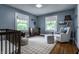 Cozy bedroom with crib, rug, rocker, ottoman, natural light, and a baseball at 5430 N Washington Blvd, Indianapolis, IN 46220