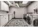 Functional laundry room features a washer, dryer, utility sink and storage cabinets with a stylish rug at 5430 N Washington Blvd, Indianapolis, IN 46220