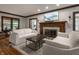 Cozy living room featuring a fireplace, white sofas, dark-wood trim, and natural light at 5430 N Washington Blvd, Indianapolis, IN 46220