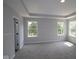 Spacious bedroom featuring plush carpeting, three windows, and modern lighting at 5517 Sienna Ct, Brownsburg, IN 46112