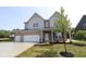 Two-story home features a three-car garage and newly installed grass and landscaping at 5517 Sienna Ct, Brownsburg, IN 46112
