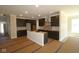 Spacious kitchen featuring dark cabinetry, stainless steel hood, and an island, offering a contemporary design at 5517 Sienna Ct, Brownsburg, IN 46112
