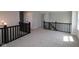 Open loft area with dark railing and neutral carpet at 5517 Sienna Ct, Brownsburg, IN 46112