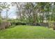 Well-maintained backyard with green grass, a wooden fence, and mature trees at 6210 Mckinley Ct, Indianapolis, IN 46220