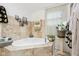 Bright bathroom featuring a tiled tub, neutral accents, and decoratively displayed towels at 6210 Mckinley Ct, Indianapolis, IN 46220