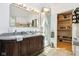 Stylish bathroom featuring a large vanity with granite countertop and storage cabinet, with a view into closet at 6210 Mckinley Ct, Indianapolis, IN 46220