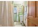 A bright bathroom with green walls, white vanity, patterned shower curtain, and natural light at 6210 Mckinley Ct, Indianapolis, IN 46220