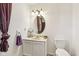 Bathroom featuring a sink vanity, oval mirror, decorative accents, and a toilet at 6210 Mckinley Ct, Indianapolis, IN 46220