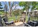 Outdoor deck with chairs and railings surrounded by lush trees and foliage at 6210 Mckinley Ct, Indianapolis, IN 46220
