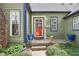 Inviting front entrance with a red door, sidelight windows, and manicured landscaping at 6210 Mckinley Ct, Indianapolis, IN 46220
