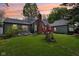 Charming home featuring a brick chimney, manicured lawn, and elegant outdoor lighting at 6210 Mckinley Ct, Indianapolis, IN 46220