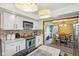 Charming kitchen with stainless steel appliances, white cabinets, and views into the dining room at 6210 Mckinley Ct, Indianapolis, IN 46220