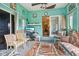 Bright sun room with teal walls, casual seating, and access to a deck area at 6210 Mckinley Ct, Indianapolis, IN 46220
