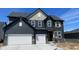 Two-story home features a two-car garage, gray siding, brick accents, and a charming, covered porch at 6418 Springtide Ct, Plainfield, IN 46168