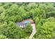 Aerial view of a home nestled among lush green trees, featuring a pool, deck, and well-maintained yard at 6530 Lowanna Way, Indianapolis, IN 46220