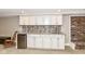 Basement wet bar with white cabinets, granite countertop, mosaic backsplash, and a beverage fridge at 6530 Lowanna Way, Indianapolis, IN 46220