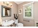 Powder room featuring a pedestal sink, a framed mirror, and a window for natural light at 6530 Lowanna Way, Indianapolis, IN 46220