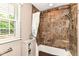 Full bath with tiled shower and tub, built-in storage, and large window at 6530 Lowanna Way, Indianapolis, IN 46220