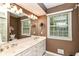Bathroom showcasing a double sink vanity, large mirror, natural light, and a nearby toilet and shower at 6530 Lowanna Way, Indianapolis, IN 46220