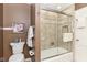 Bathroom with tiled shower featuring a glass sliding door, a toilet, and a towel rack at 6530 Lowanna Way, Indianapolis, IN 46220