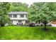 Charming two-story home featuring a manicured lawn and lush landscaping at 6530 Lowanna Way, Indianapolis, IN 46220
