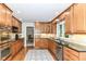 Spacious kitchen featuring stainless steel appliances, wood cabinetry, and granite countertops at 6530 Lowanna Way, Indianapolis, IN 46220