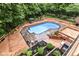 An aerial view of the backyard featuring a large in-ground pool, mature trees, and a wooden fence at 6530 Lowanna Way, Indianapolis, IN 46220