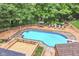 Elevated view of the pool surrounded by an expansive deck, seating, lush greenery, and a pool house at 6530 Lowanna Way, Indianapolis, IN 46220