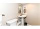 Powder room featuring a pedestal sink, toilet, neutral color scheme, and framed mirror at 6530 Lowanna Way, Indianapolis, IN 46220