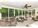 Inviting sunroom featuring wicker furniture, a ceiling fan, and views of the landscaped backyard and pool at 6530 Lowanna Way, Indianapolis, IN 46220