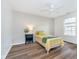 Bedroom featuring wood-look floors, a ceiling fan, and a view from the window at 6789 Passage Cir, Indianapolis, IN 46250