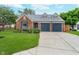 Charming brick home featuring a two-car garage, well-manicured lawn, and colorful flower beds at 6789 Passage Cir, Indianapolis, IN 46250