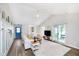 Bright living room with vaulted ceiling, kitchen view, and sliding door access to sunroom at 6789 Passage Cir, Indianapolis, IN 46250