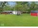Spacious green backyard featuring a large shed, playset, and well-maintained lawn at 679 Bark Dr, Anderson, IN 46011