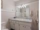 Neutral bathroom featuring tile walls, vanity with white cabinets, and decorative light fixture at 679 Bark Dr, Anderson, IN 46011