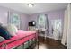 Bright bedroom with lavender walls, featuring two windows, a writing desk and a cozy bed at 679 Bark Dr, Anderson, IN 46011
