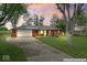 Charming red brick home with a metal roof, green door, and a well-maintained front yard at 679 Bark Dr, Anderson, IN 46011