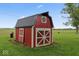 The property features a red barn, with a black metal roof, with white trim on an expansive green lawn at 679 Bark Dr, Anderson, IN 46011