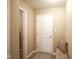 Bright hallway with a white entry door, carpet, bench, and a decorative pillow at 695 Overcup St, Westfield, IN 46074