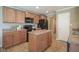 Kitchen with wood cabinets, black appliances, an island, and tile flooring at 695 Overcup St, Westfield, IN 46074