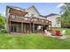 Backyard featuring a two-level deck, fire pit, brick patio, picnic tables, and green lawn at 7022 Tamarind Ct, Indianapolis, IN 46236
