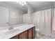 Neutral bathroom featuring wood vanity, large mirror, and shower with patterned curtain at 7022 Tamarind Ct, Indianapolis, IN 46236