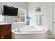 Bathroom with soaking tub, large window, and modern fixtures at 7022 Tamarind Ct, Indianapolis, IN 46236