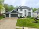 Beautiful two-story white home featuring a three-car garage, manicured lawn, and elegant landscaping at 7022 Tamarind Ct, Indianapolis, IN 46236